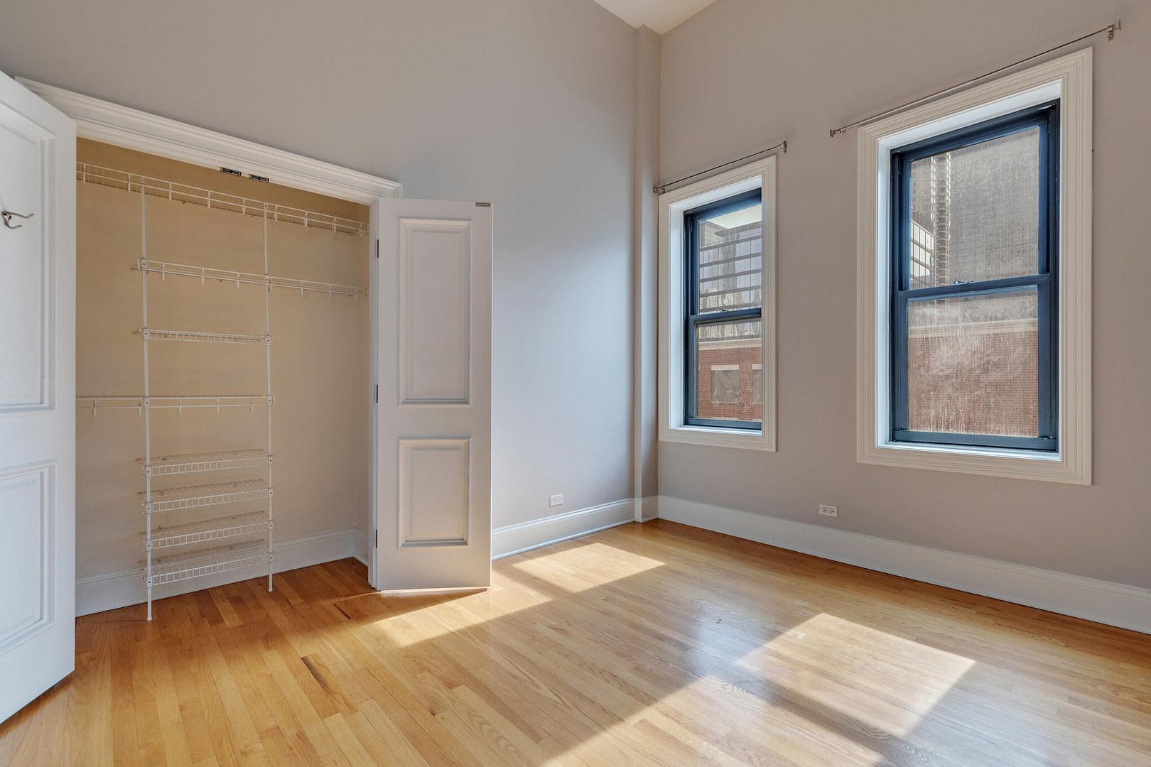 166 West Grand Avenue, Unit 3B Chicago, IL 60654 - Photo 4 of 16 a view of an empty room with window and wooden floor