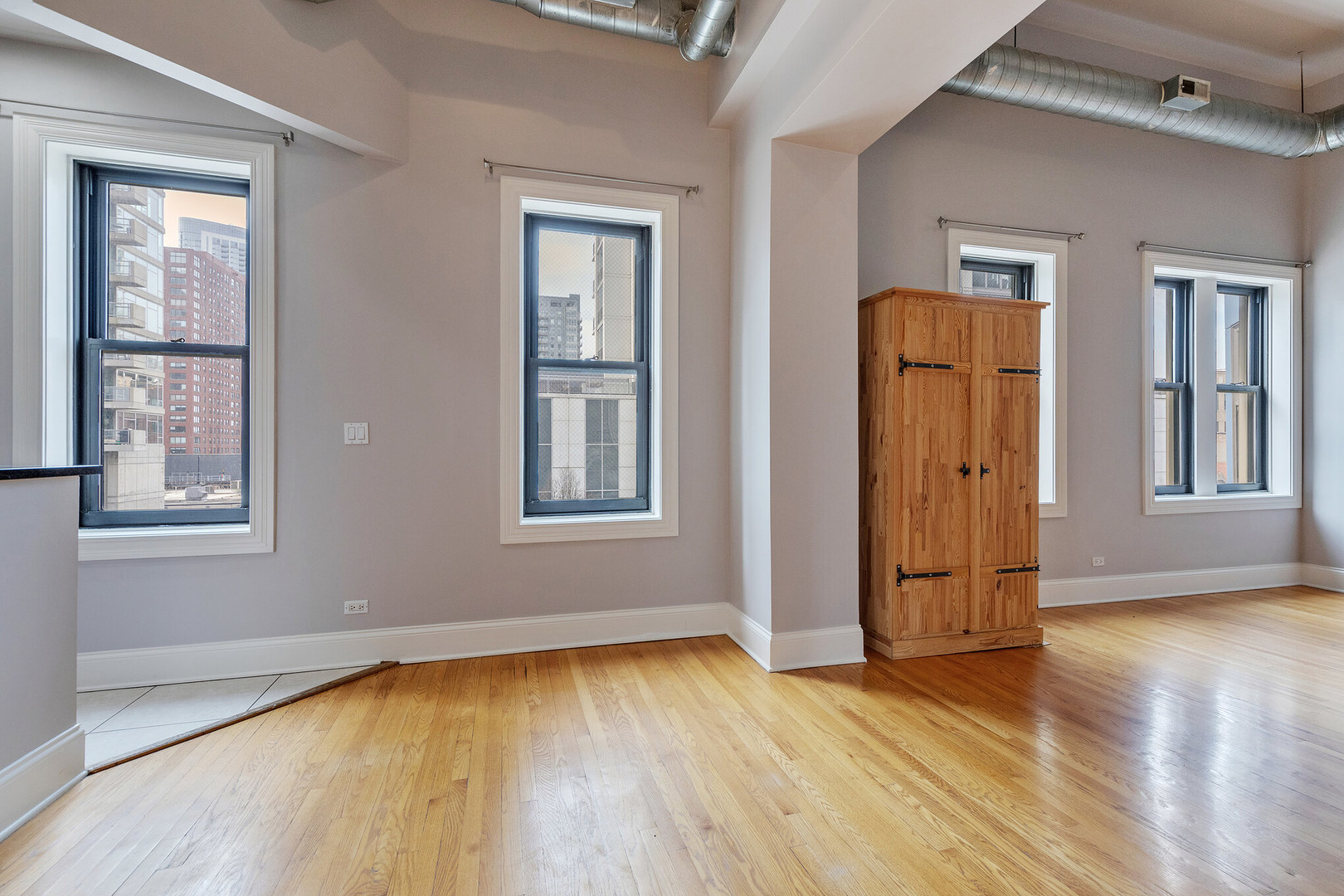 166 West Grand Avenue, Unit 3B Chicago, IL 60654 - Photo 5 of 16 an empty room with wooden floor and windows