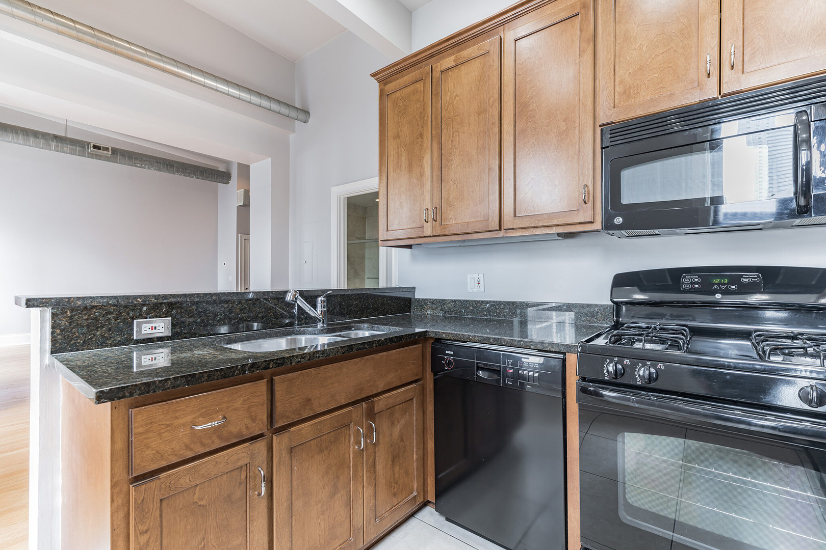 166 West Grand Avenue, Unit 3B Chicago, IL 60654 - Photo 8 of 16 a kitchen with stainless steel appliances granite countertop a sink stove and cabinets