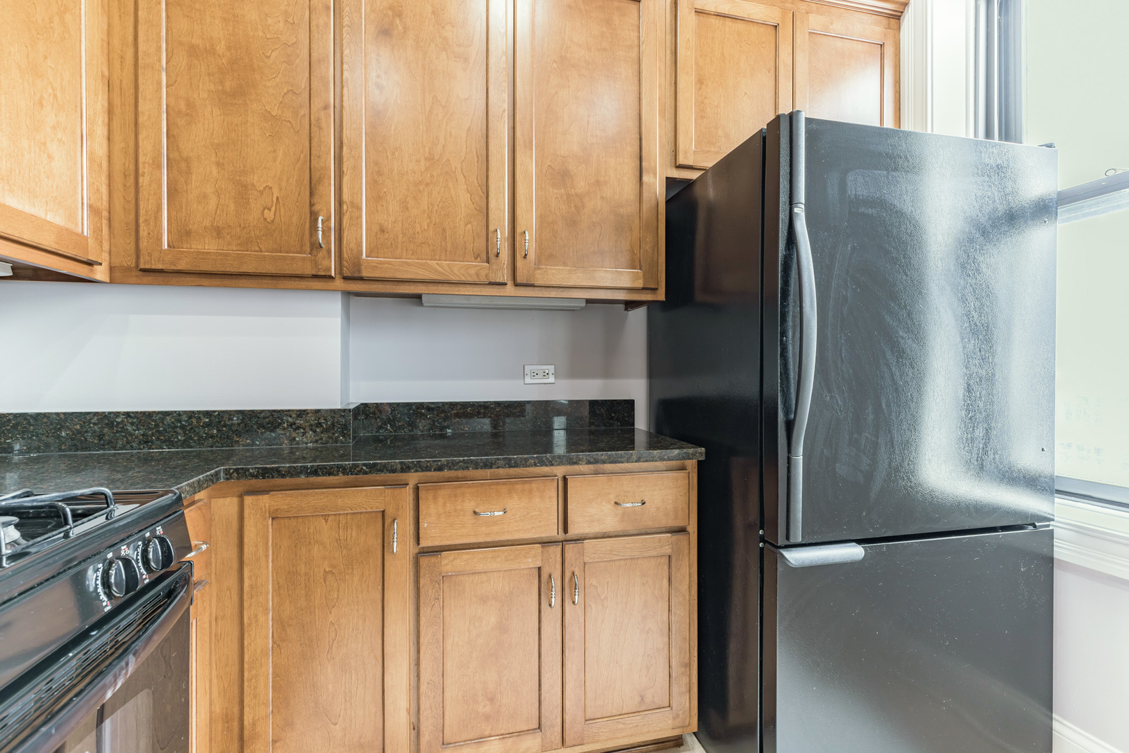 166 West Grand Avenue, Unit 3B Chicago, IL 60654 - Photo 10 of 16 a kitchen with stainless steel appliances granite countertop a refrigerator a stove and white cabinets with wooden floor