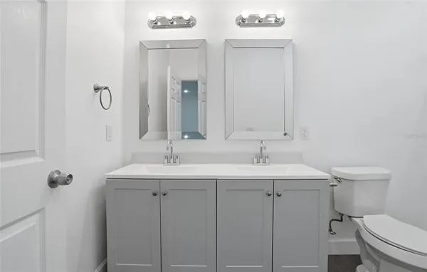 a bathroom with a toilet a sink and mirror