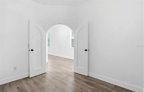 a view of empty room with wooden floor