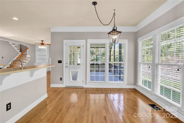 a view of a room with wooden floor and windows