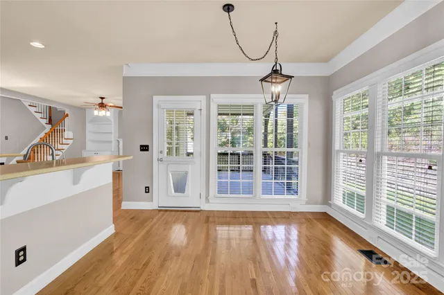 a view of a room with wooden floor and windows
