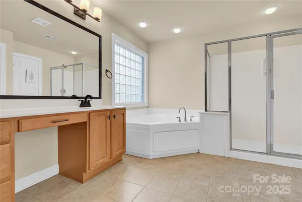 a bathroom with a double vanity sink a mirror and a bathtub