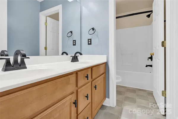 a bathroom with a sink and a mirror with shower