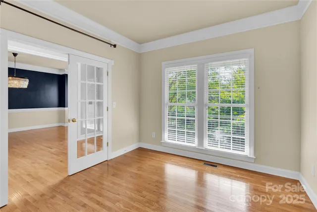 a view of a big room with wooden floor and windows