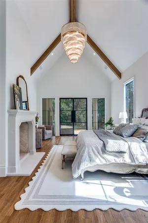 a bed sitting in a bedroom next to a window with a chandelier