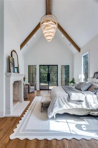 a bed sitting in a bedroom next to a window with a chandelier