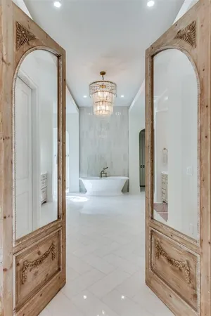 a view of a hallway with windows and chandelier