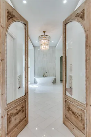a view of a hallway with windows and chandelier