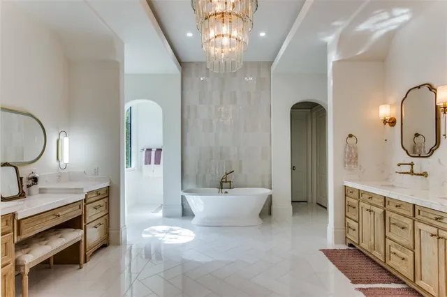 a spacious bathroom with a double vanity sink a mirror a bathtub and a shower