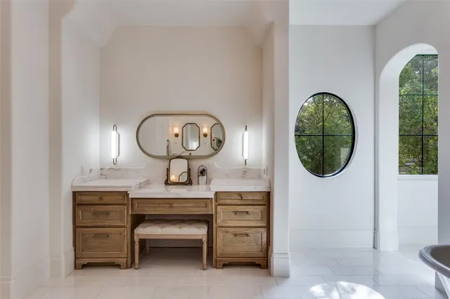 a room with a furniture a mirror and a window