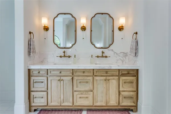 a bathroom with double vanity sinks and a mirror