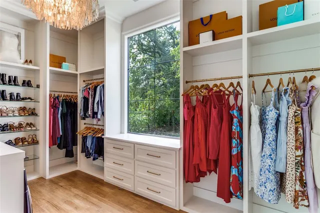 a view of walk in closet with clothes and shoes