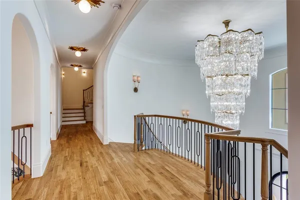 a view of a hallway with wooden floor and staircase