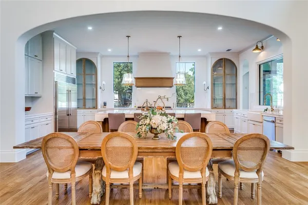 a dining room with furniture a large window and wooden floor