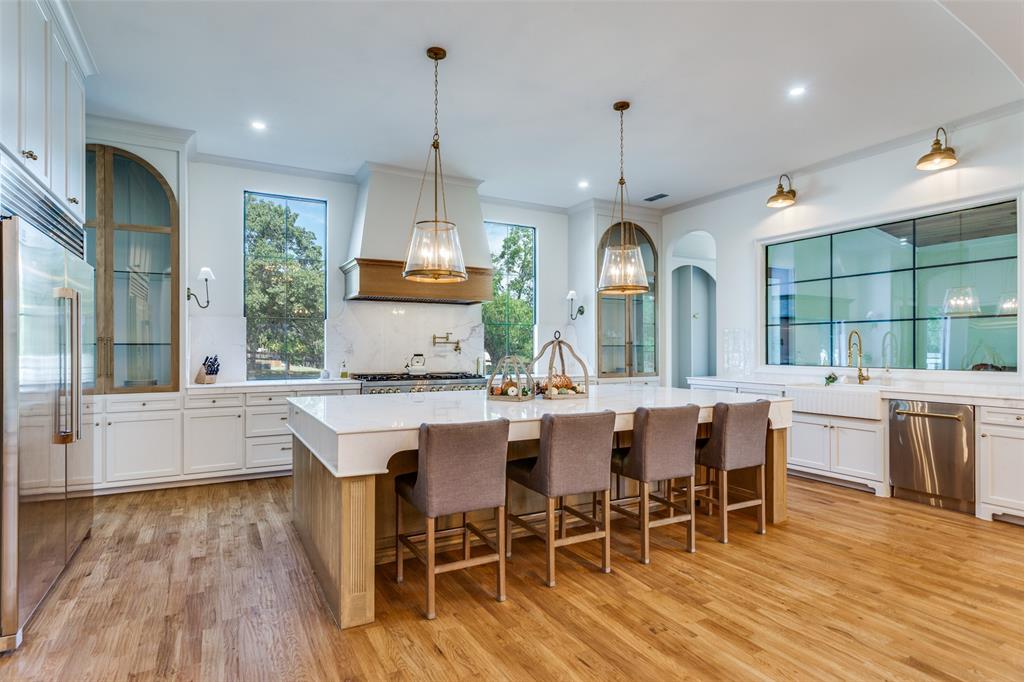 1133 Bourland Road Keller, TX 76248 - Photo 8 of 39 a kitchen with stainless steel appliances granite countertop a stove a refrigerator a kitchen island a dining table and chairs