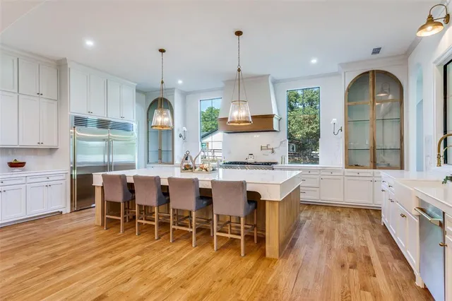 a kitchen with stainless steel appliances granite countertop a kitchen island a stove a table and chairs in it