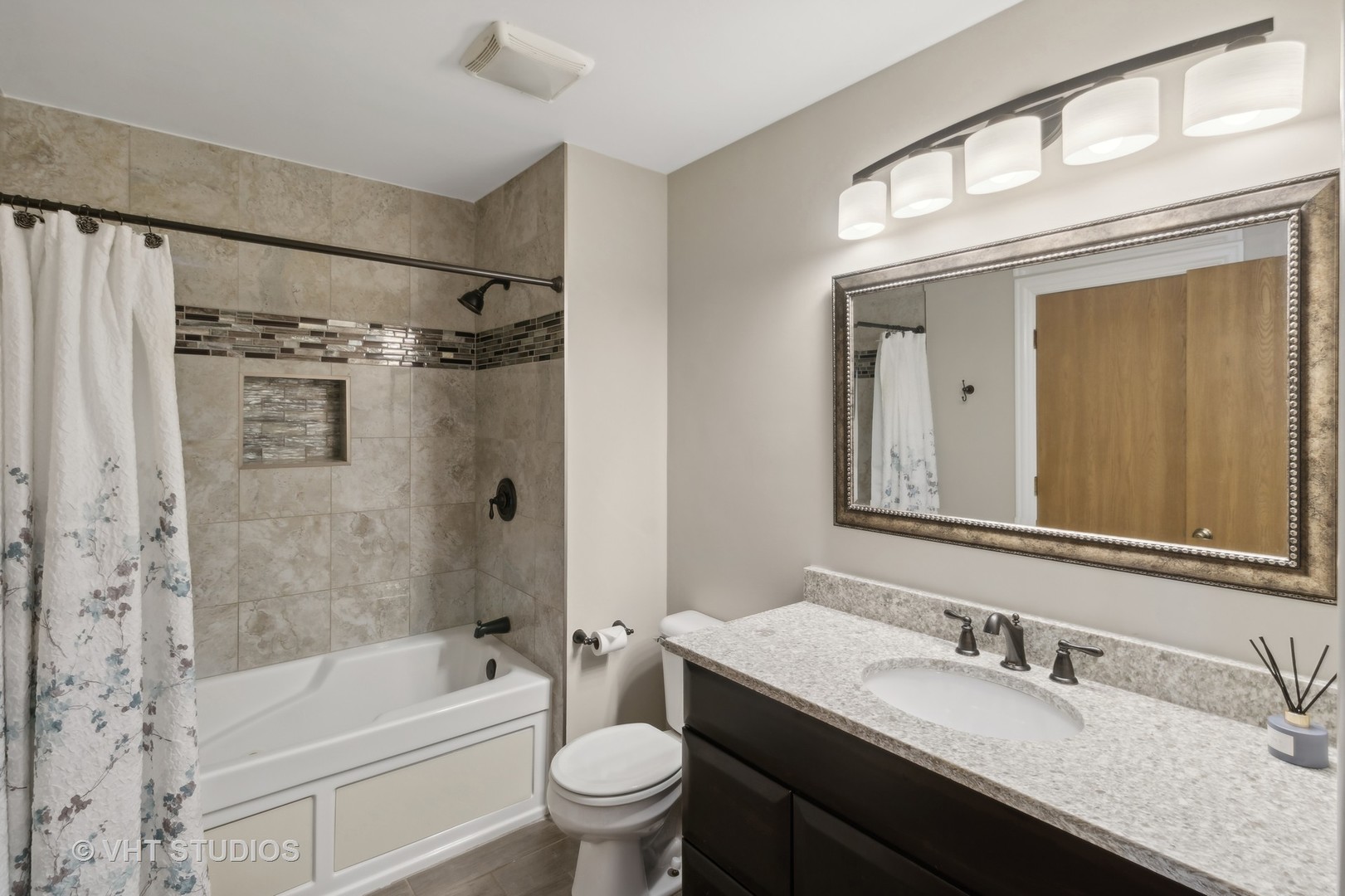 909 Ridgefield Lane Wheeling, IL 60090 - Photo 14 of 20 a bathroom with a granite countertop sink a toilet a mirror a bathtub and shower