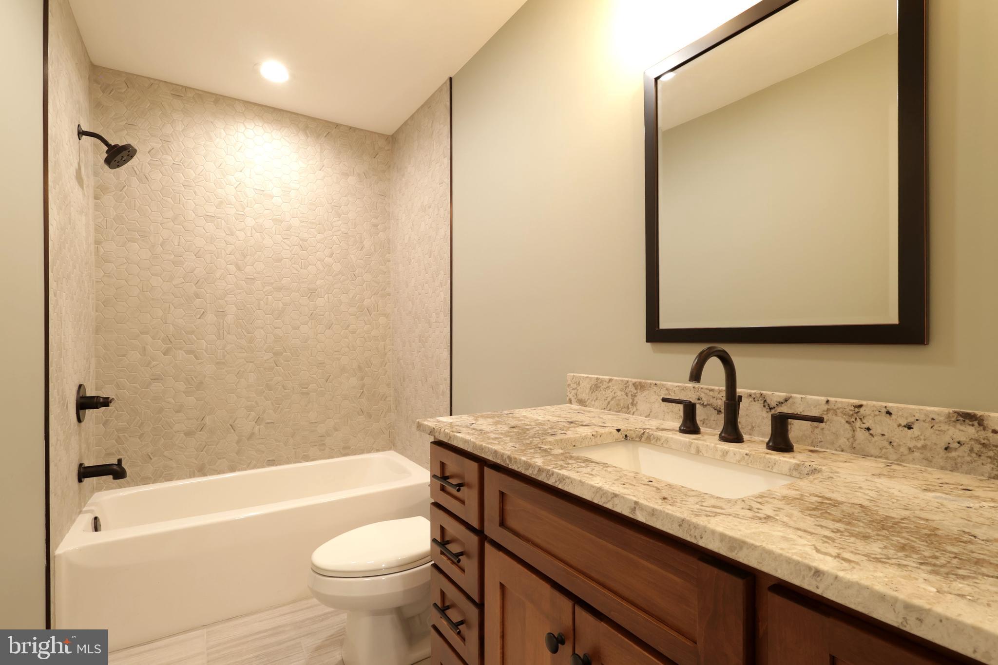 518 Two Mile Road Howard, PA 16841 - Photo 47 of 84 a bathroom with a granite countertop sink a toilet a mirror a bathtub and shower