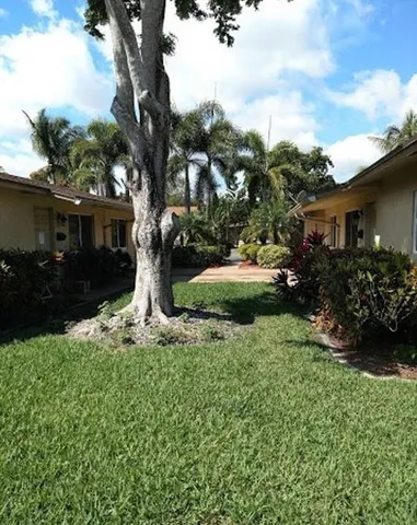 a view of a pathway of a house with a yard