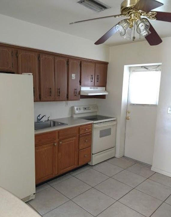 408 Northeast 12th Avenue, Unit 2 Pompano Beach, FL 33060 - Photo 6 of 14 a kitchen with stainless steel appliances granite countertop a sink and dishwasher a refrigerator with wooden cabinets