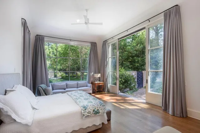 a bedroom with a bed and large windows