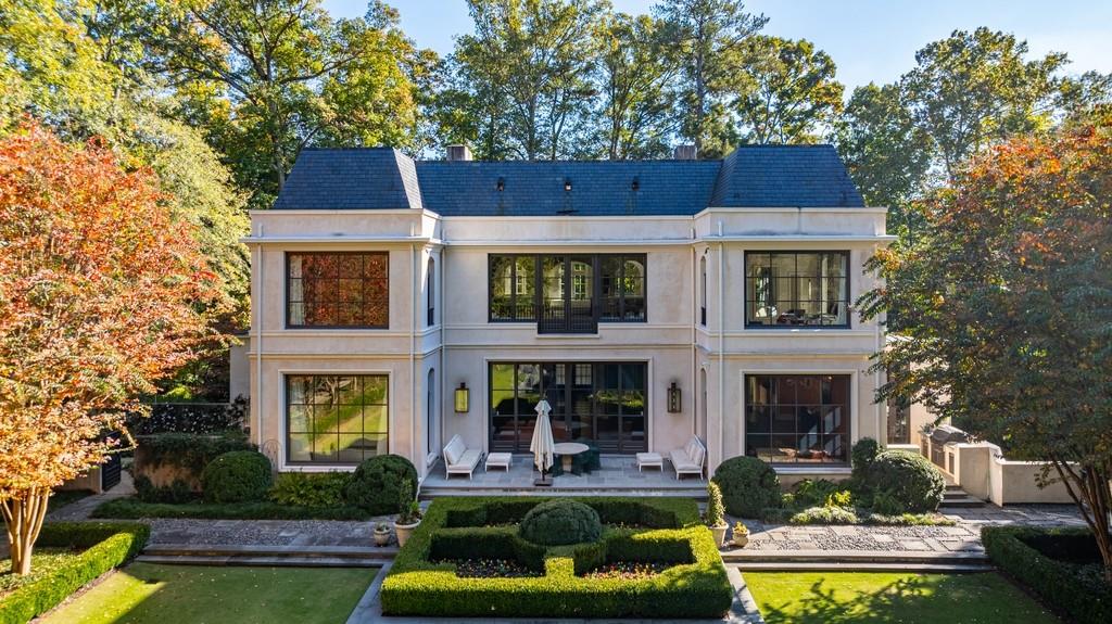 133 Blackland Road Northwest Atlanta, GA 30342 - Photo 2 of 38 a front view of a house with swimming pool and a yard table and chairs