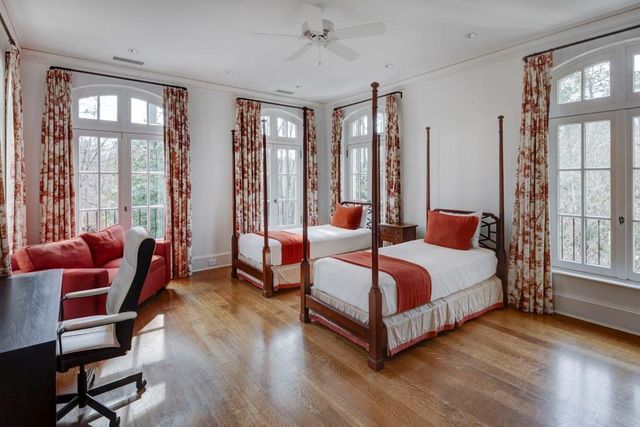 a spacious bedroom with a bed and a couch next to a window