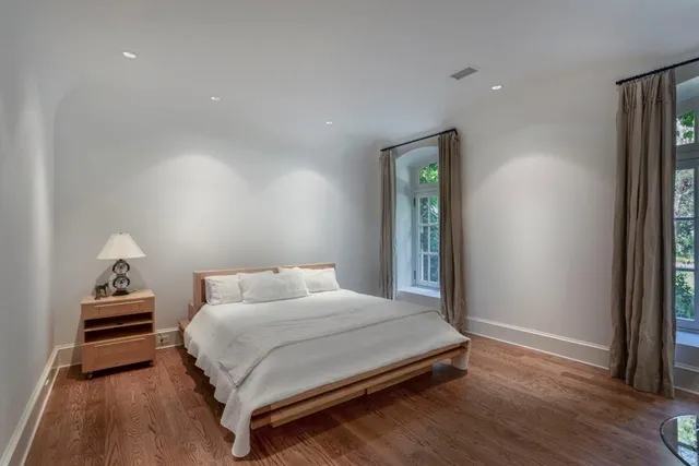a bedroom with a bed and wooden floor