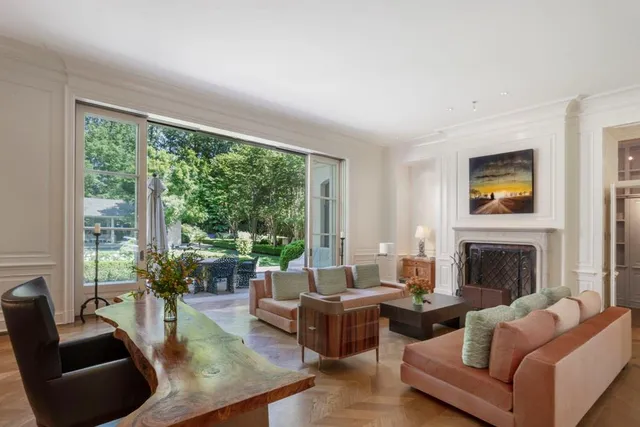 a living room with furniture fireplace and a large window