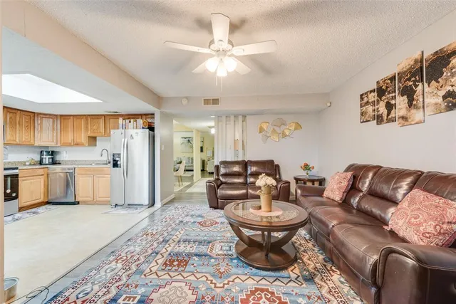 a living room with furniture and a view of kitchen