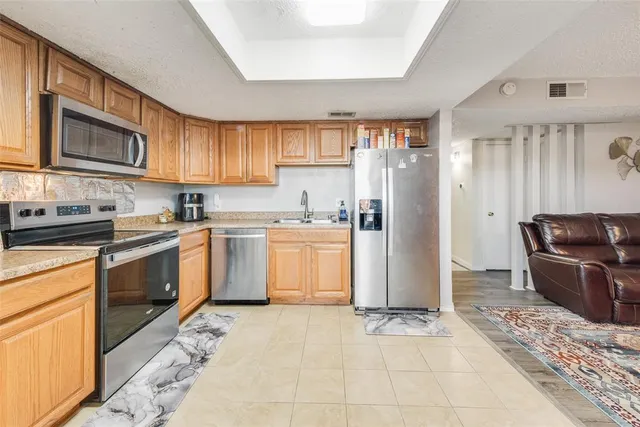 a kitchen with a refrigerator sink and cabinets