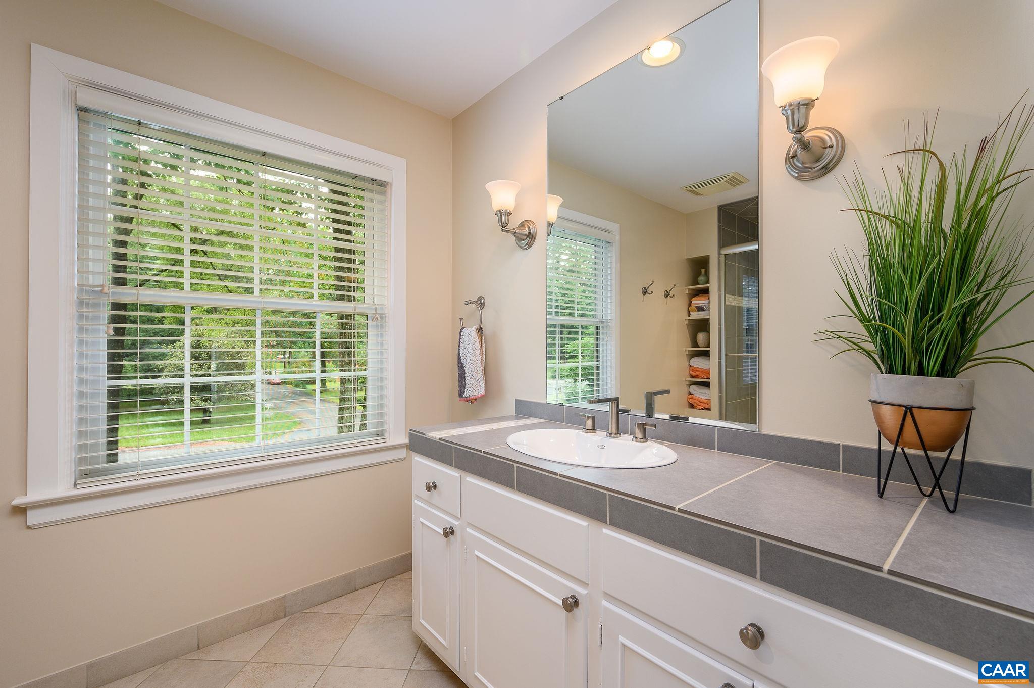 109 Sturbridge Road Charlottesville, VA 22901 - Photo 24 of 36 a bathroom with a granite countertop sink a large mirror and a window