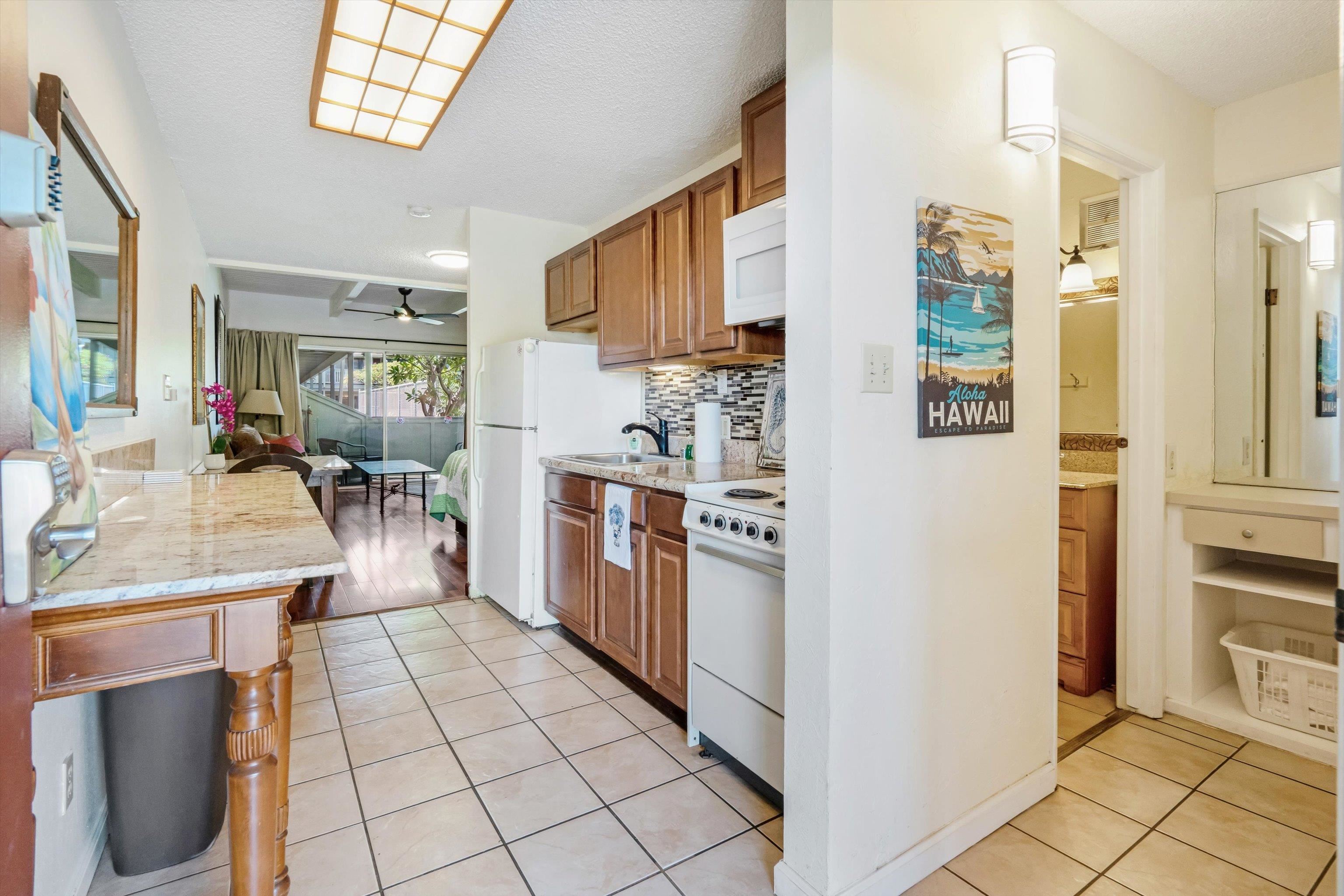 715 South Kihei Road, Unit B 120 Kihei, HI 96753 - Photo 5 of 36 a kitchen with stainless steel appliances kitchen island granite countertop a refrigerator and a stove