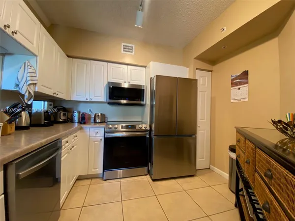 a kitchen with stainless steel appliances granite countertop a refrigerator and a stove top oven