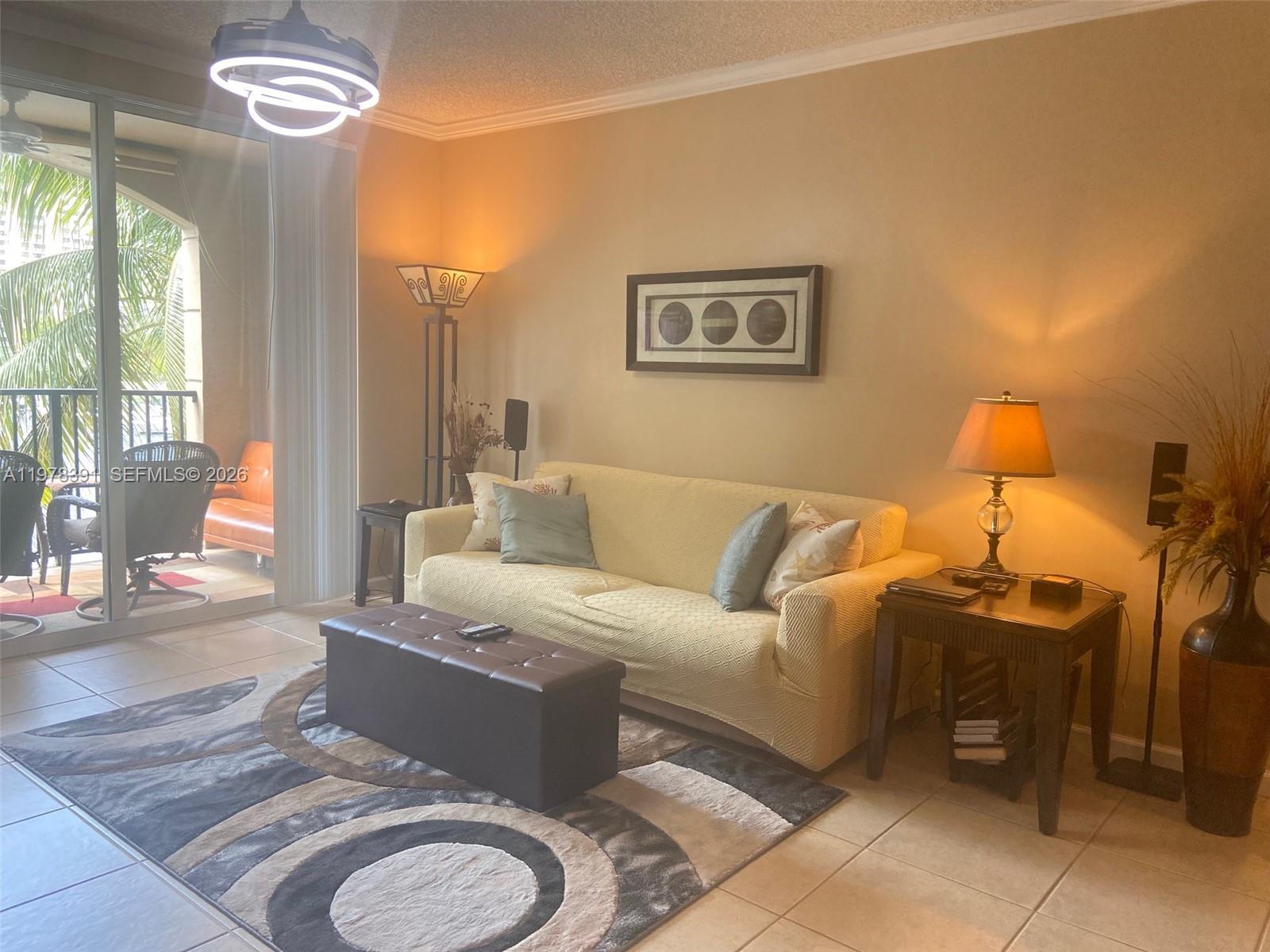 17150 North Bay Road, Unit 2406 Sunny Isles Beach, FL 33160 - Photo 5 of 22 a living room with furniture a chandelier and a window