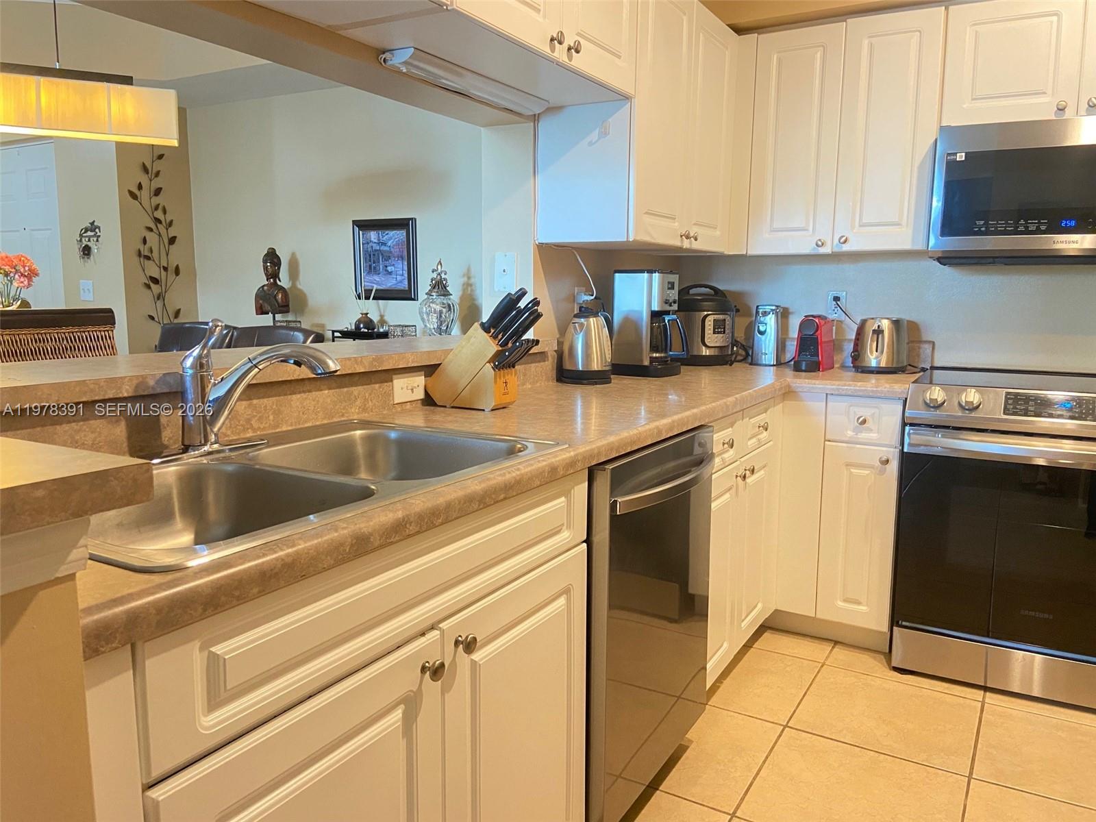 17150 North Bay Road, Unit 2406 Sunny Isles Beach, FL 33160 - Photo 7 of 22 a kitchen with stainless steel appliances granite countertop a sink stove and cabinets