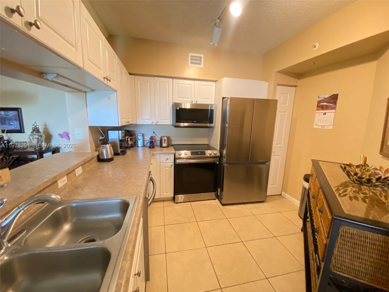 17150 North Bay Road, Unit 2406 Sunny Isles Beach, FL 33160 - Photo 8 of 22 a kitchen with stainless steel appliances granite countertop a refrigerator and a stove