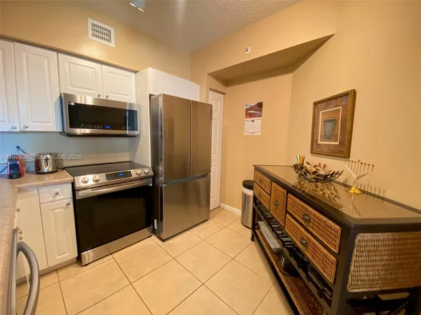 a kitchen with stainless steel appliances a stove microwave and refrigerator