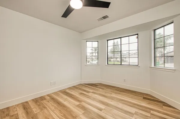 an empty room with a window and wooden floor