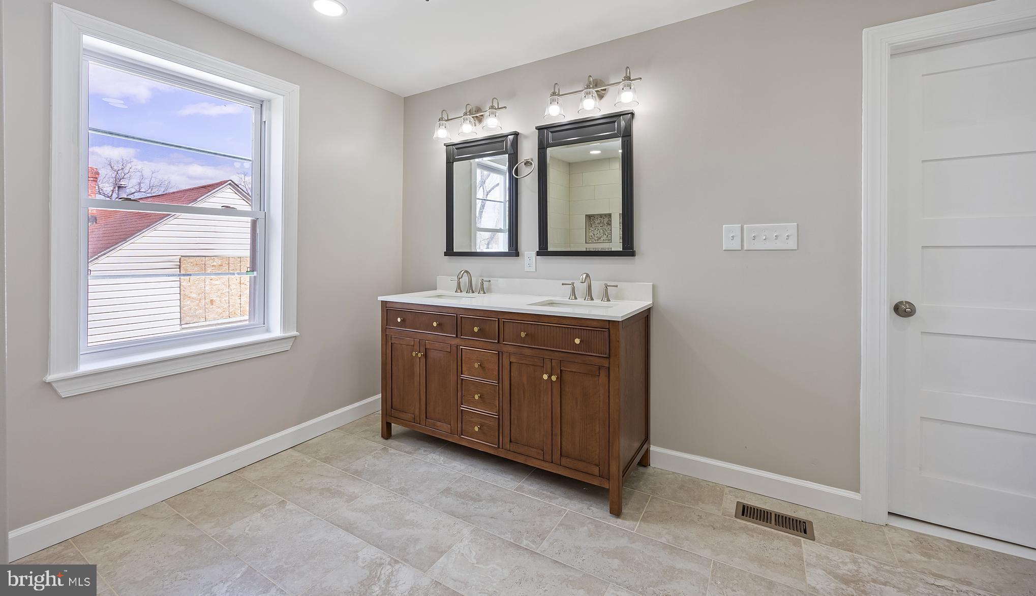 3908 Primrose Avenue Baltimore, MD 21215 - Photo 12 of 19 a bathroom with a granite countertop double vanity sink a mirror and a