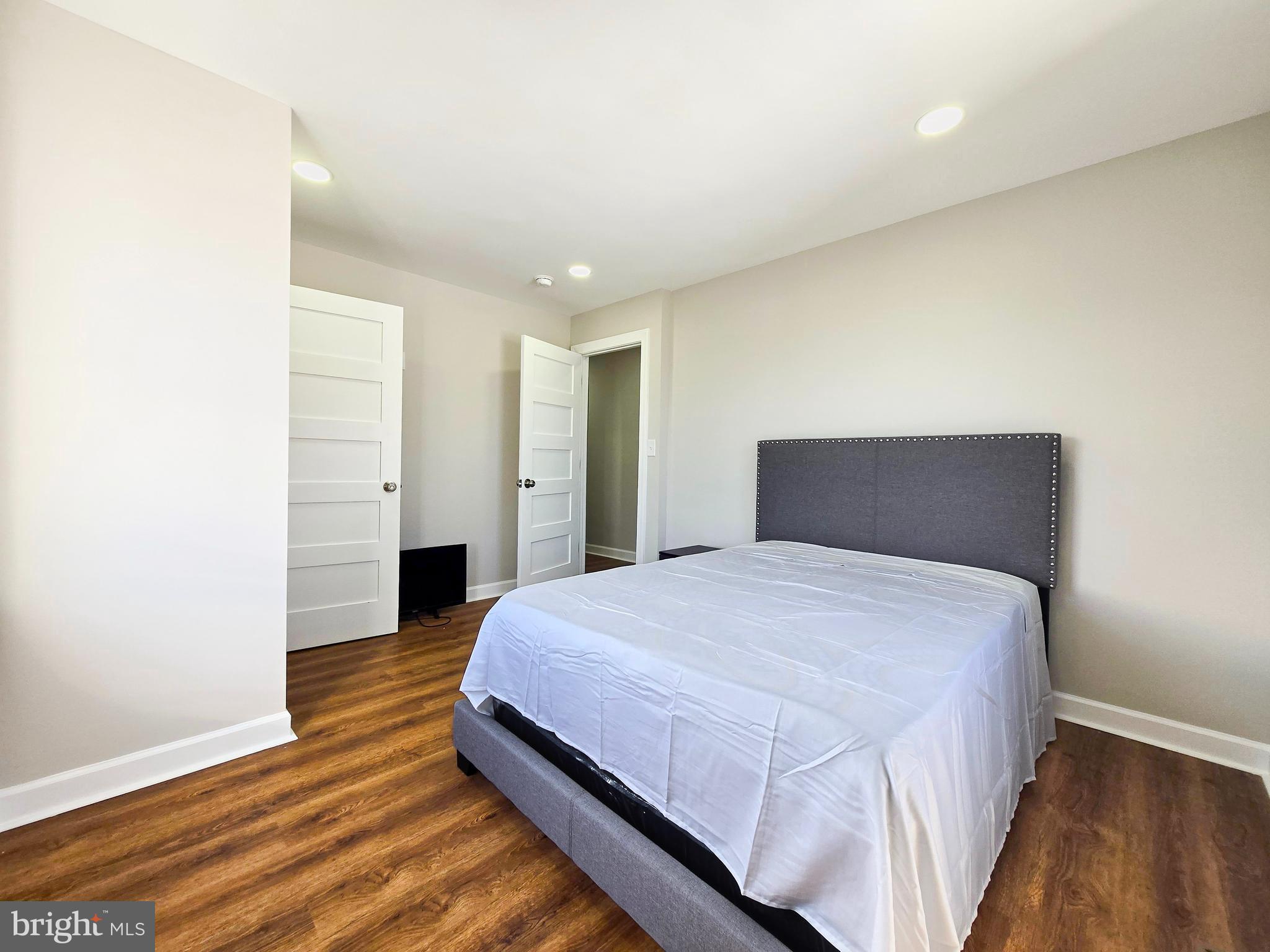 3908 Primrose Avenue Baltimore, MD 21215 - Photo 14 of 19 a bedroom with a bed and wooden floor