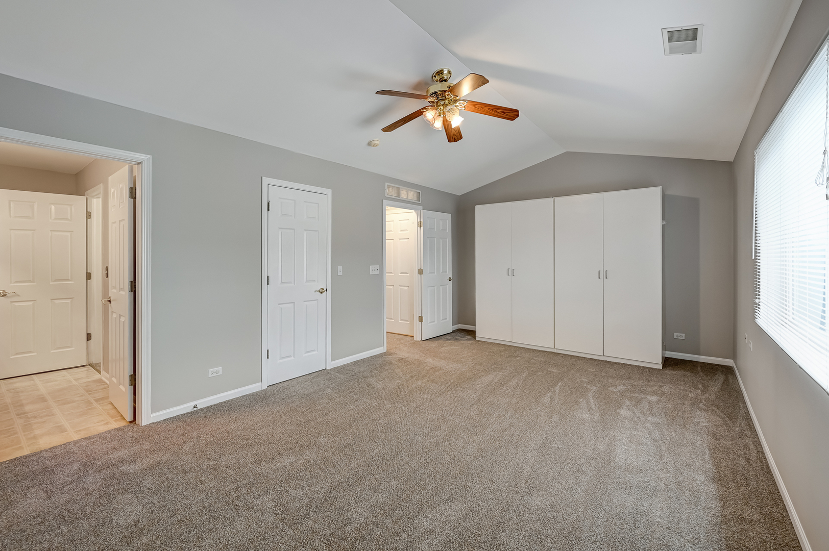 118 Enclave Circle, Unit C Bolingbrook, IL 60440 - Photo 16 of 27 an empty room with a window and a ceiling fan