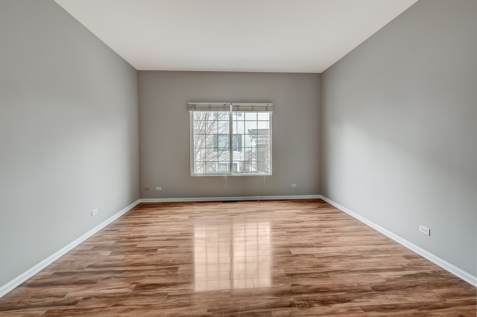 118 Enclave Circle, Unit C Bolingbrook, IL 60440 - Photo 4 of 27 a view of an empty room with wooden floor and a window