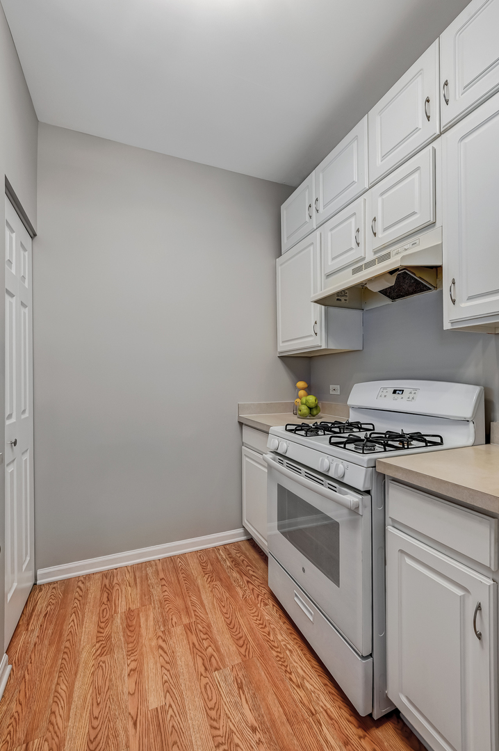 118 Enclave Circle, Unit C Bolingbrook, IL 60440 - Photo 8 of 27 a white stove top oven sitting inside of a kitchen