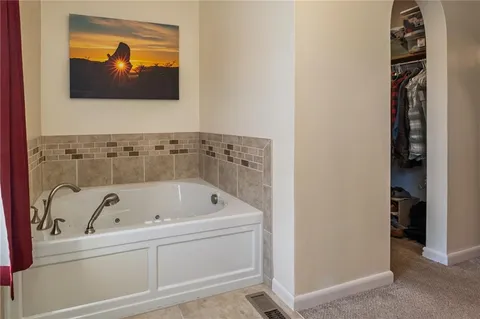 a bathroom with a tub and a painting on the wall