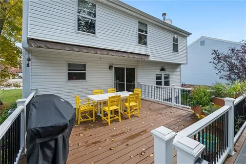 a view of a house with wooden deck and furniture