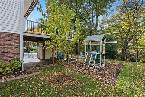 a view of a brick house with a yard and table under an umbrella